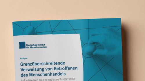 Brosch&uuml;rencover in den H&auml;nden einer Person: blaue Publikation des Deutschen Instituts f&uuml;r Menschenrechte mit dem Titel &sbquo;Grenz&uuml;berschreitende Verweisung von Betroffenen des Menschenhandels&lsquo; und Untertitel &sbquo;Anforderungen an eine nationale Kontaktstelle in Deutschland&lsquo;.