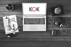 Laptop auf dem Schreibtisch mit KOK-Logo auf dem Bildschirm