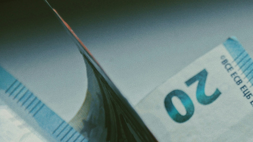 Ein Bündel Geldscheine liegt auf einem Tisch: zwei Zwanzig Euro Scheine, ein fünfzig Euro Schein, ein Fünf Euro Schein und im Anschnitt noch ein weiterer Zwanziger