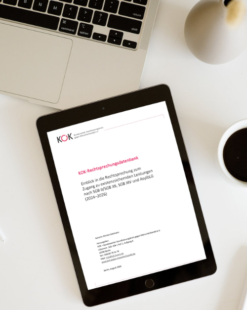 Draufsicht auf einen Schreibtisch mit Laptop, Kaffeetasse und Tablet. Auf dem Tablet ist ein Dokument mit der Überschrift KOK-Rechtsprechungsdatenbank zu sehen.